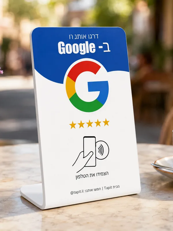כרטיס tapit עומד על שולחן שיש בבית קפה, אגרטל פרחים בצד